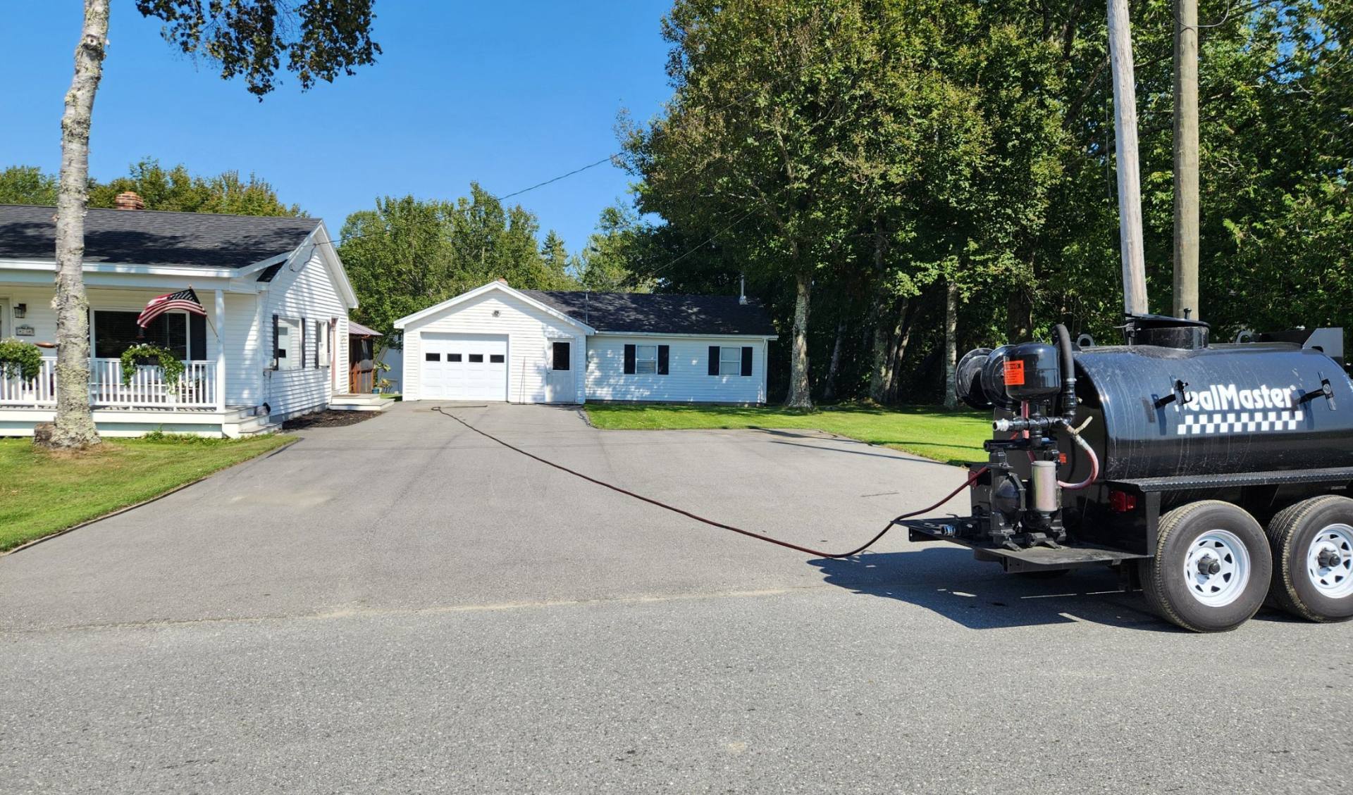 Freshly sealcoated driveway in front of a white garage