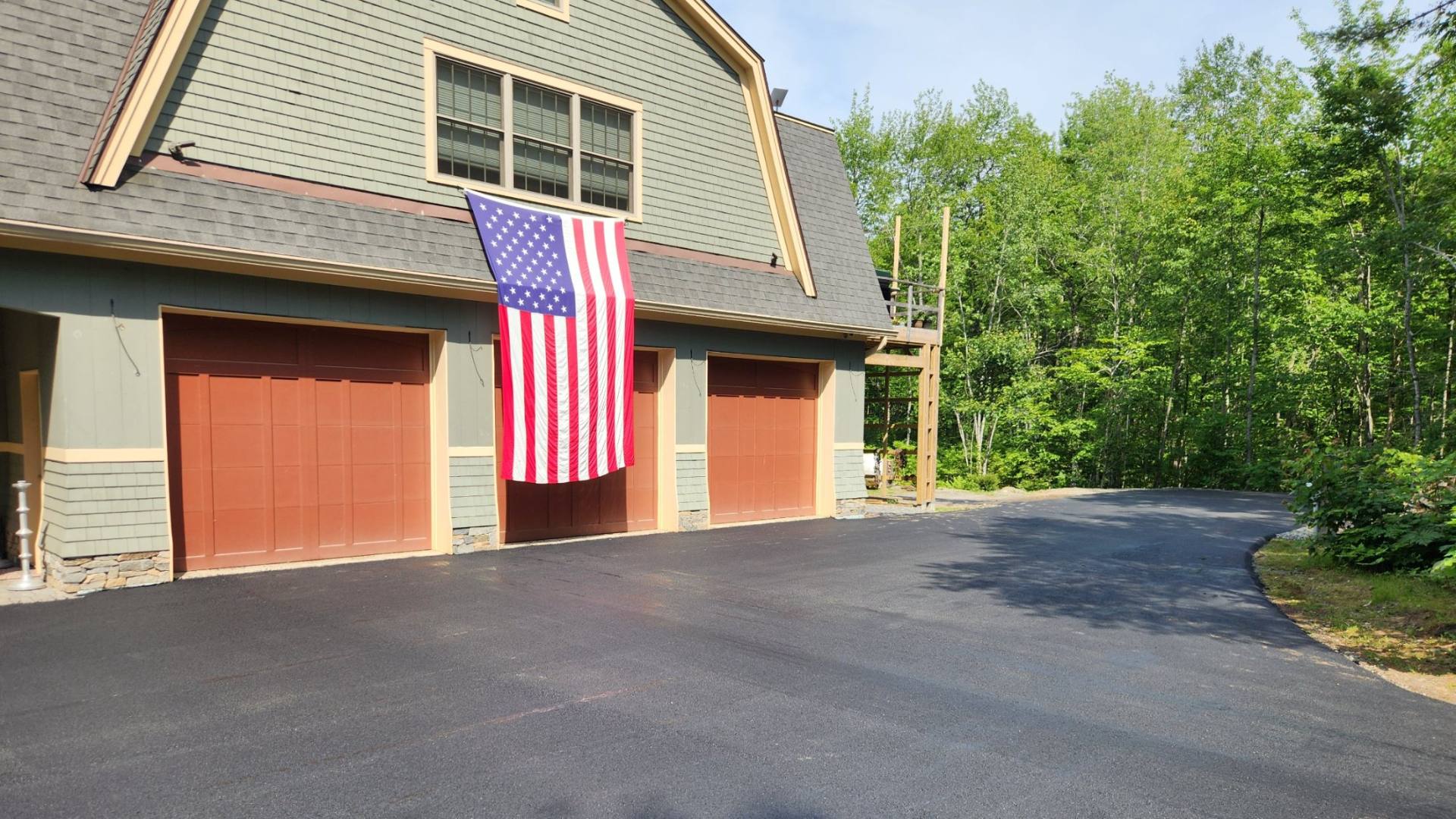 Finished driveway in front of a garage with the flag out