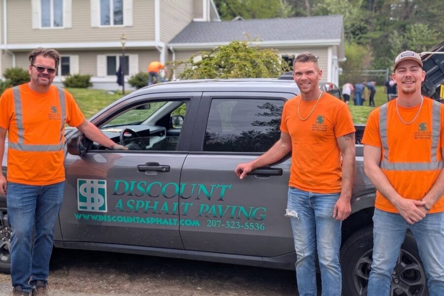 Owner and crew on site in company shirts by the truck